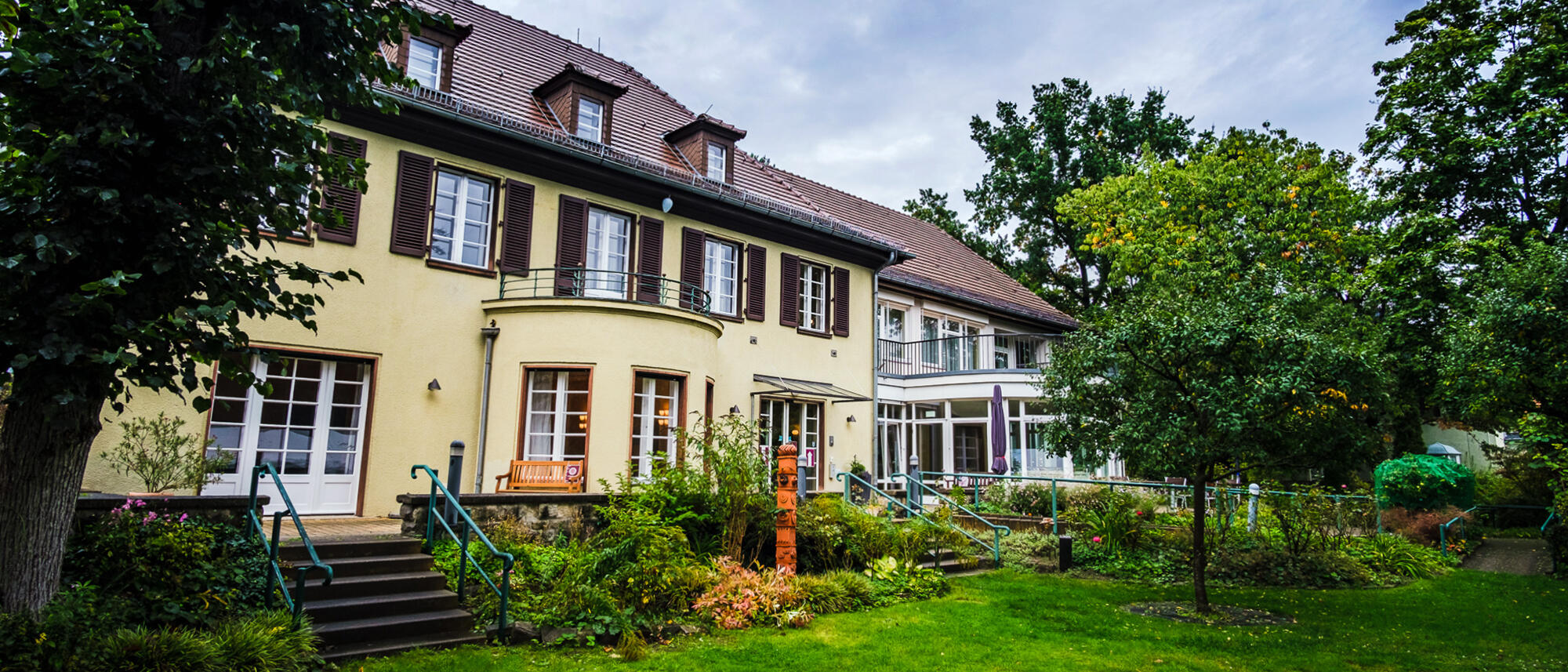 Foto: Die Villa Donnersmarck unter blauem Himmel in der Totalen, vom Garten aus fotografiert