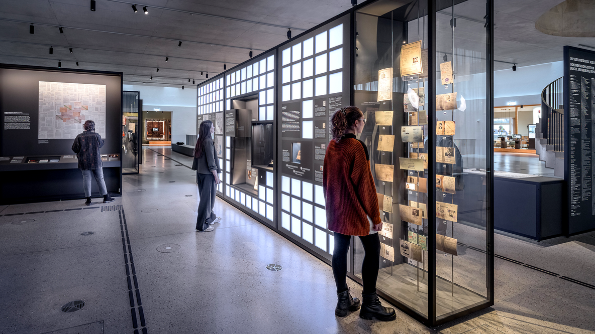 Foto: Blick ins Dokumentatuíonszentrum, personen, die in Glaskästen schauen; Foto: C. Gröteke, SFVV