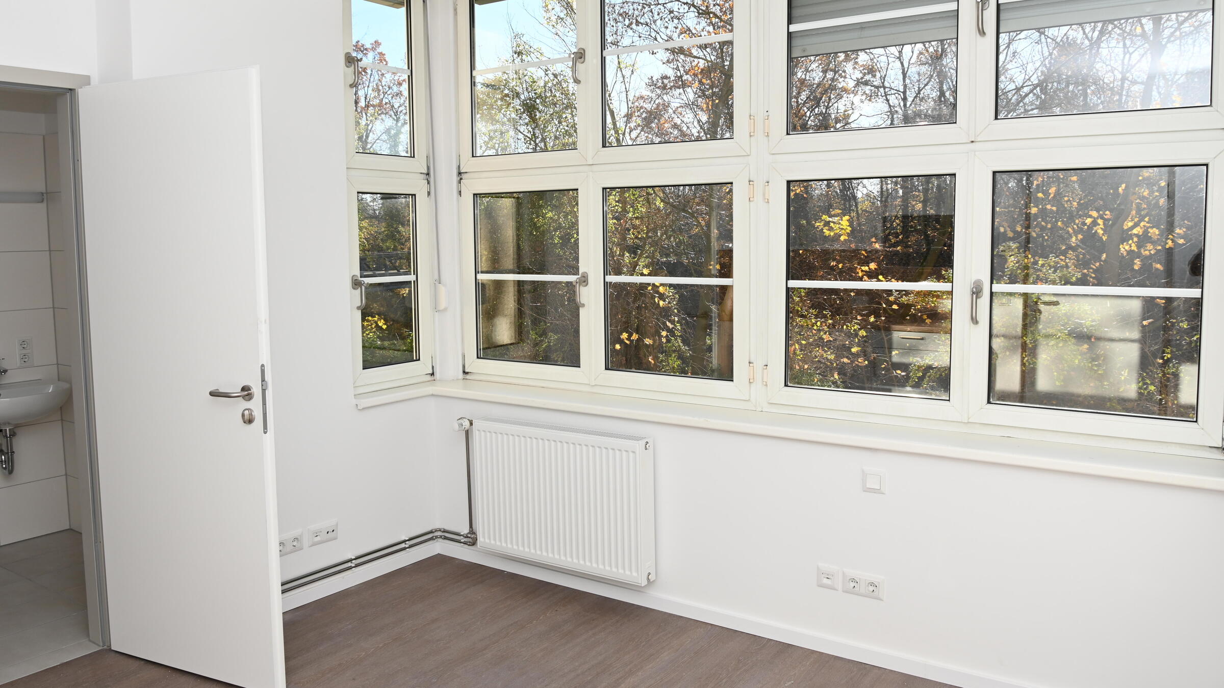 Blick in ein Appartement mit großer Fensterfront.
