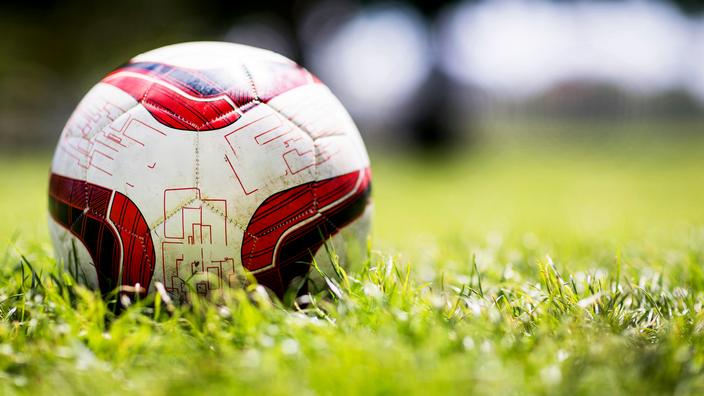 Foto: Ein Fußball auf dem Spielfeldrasen in Nahaufnahme