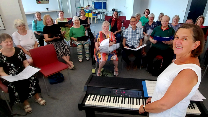 Foto: Der inklusive Chor der FDST, eine diverse inklusive Gruppe, im Vordergrund Chorleiterin am E-Piano 