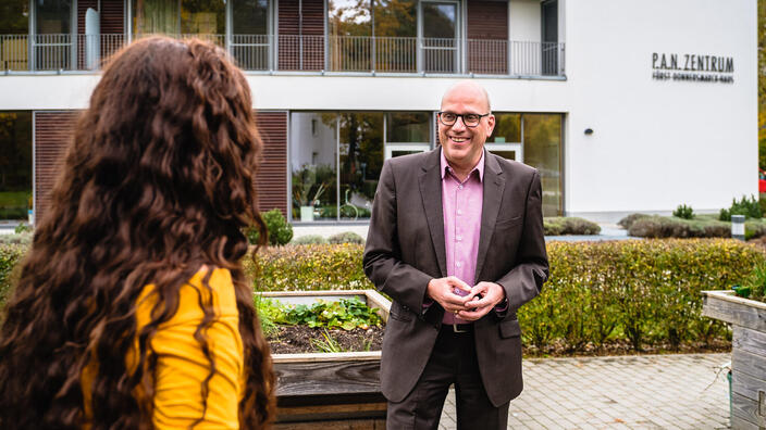 Eine Frau unterhält sich vor dem P.A.N. Zentrum mit dem Chefarzt Dr. Dohle.