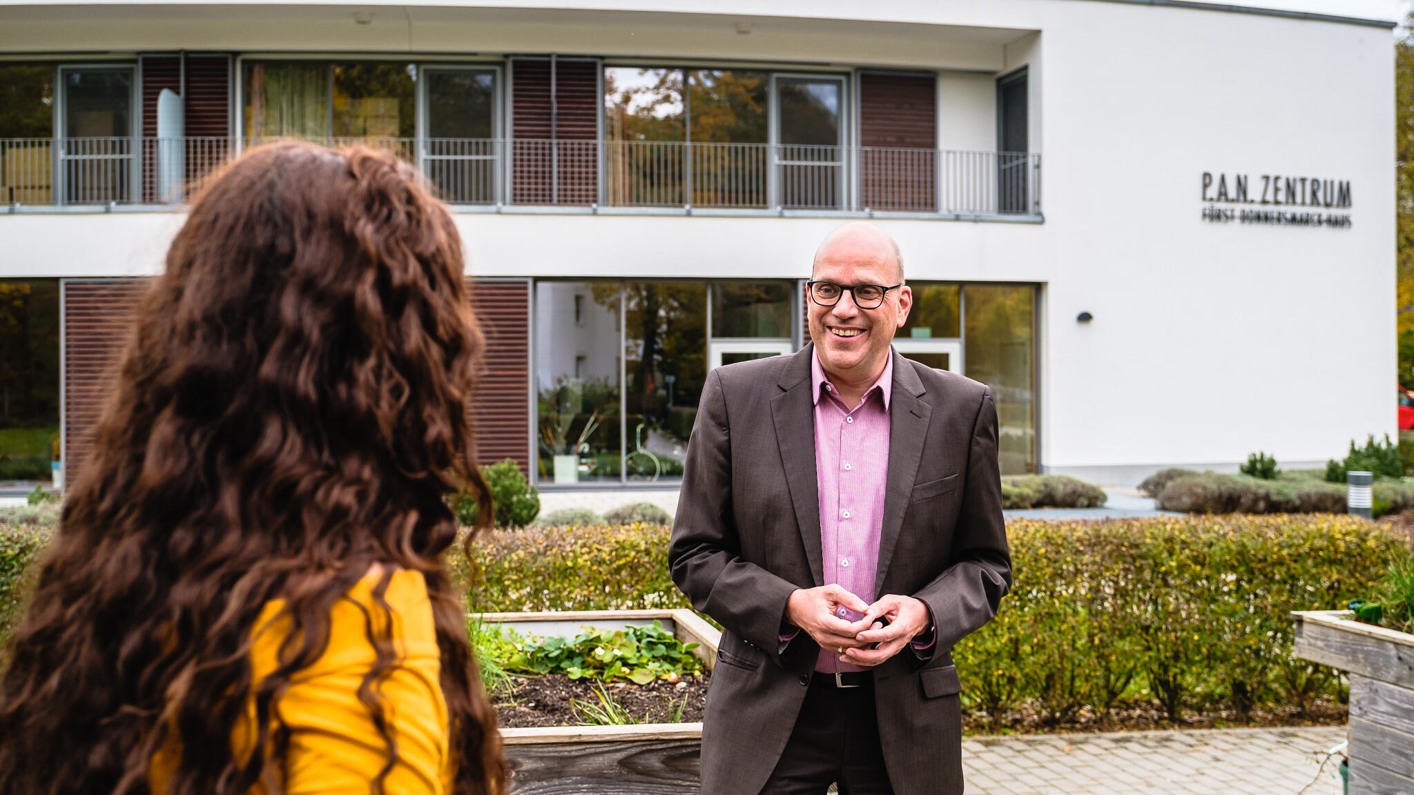 Eine Frau unterhält sich vor dem P.A.N. Zentrum mit dem Chefarzt Dr. Dohle.