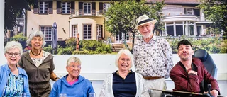 Foto: Eine gemischte Gruppe von sechs Personen hinter einem Tisch, auf dem drei Pflanzen in quadratischen Betonbehältern auf einer bordeauxfarbenen Tischdecke stehen; im Hintergrund an der Wand ein übergroßes Bild von der Villa Donnersmarck; die Damen links und 2. von links sitzen im Rollstuhl, ebenso wie der lachende junge Mann rechts
