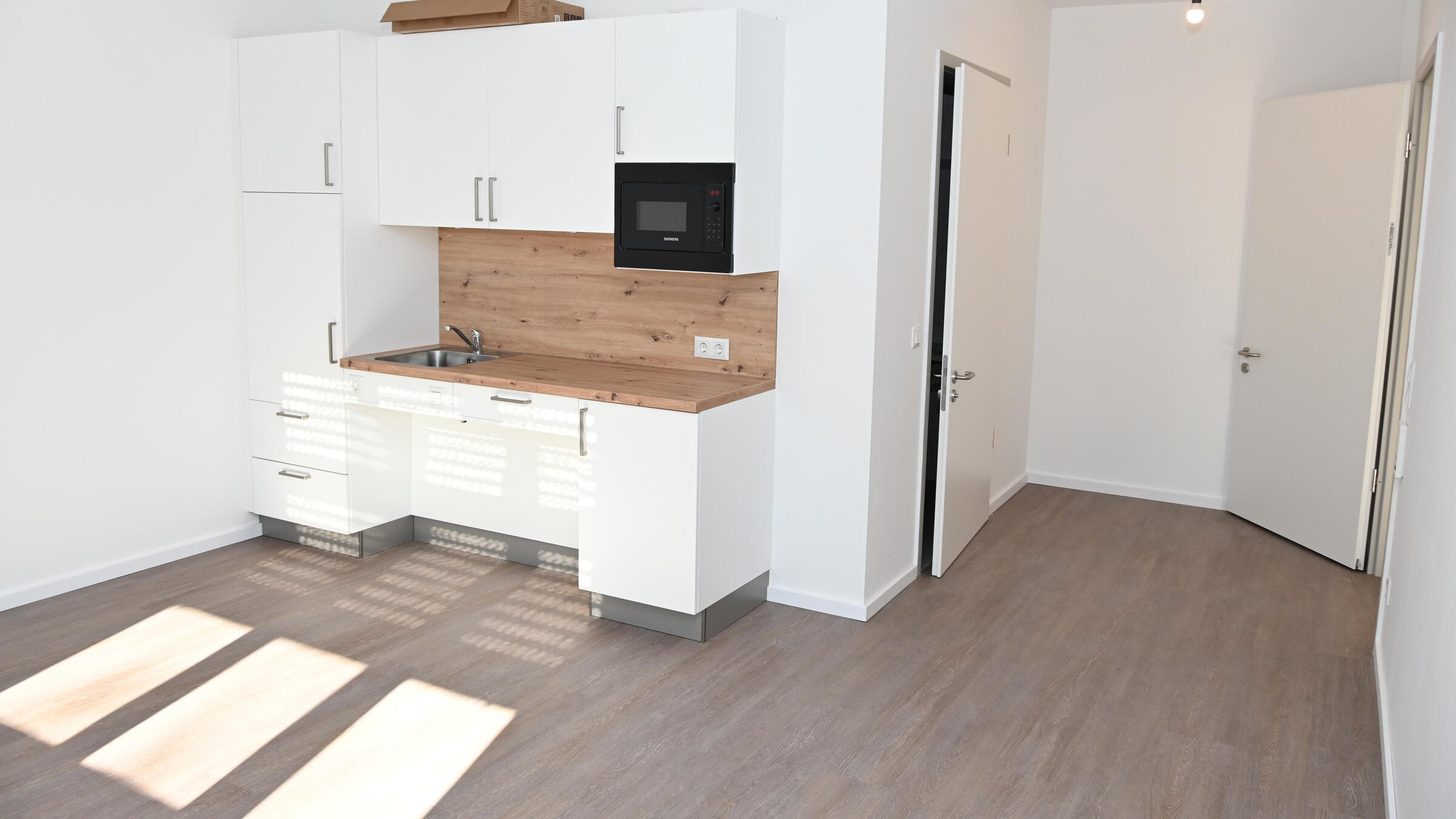 Blick in ein Appartement und auf die Kitchenette.