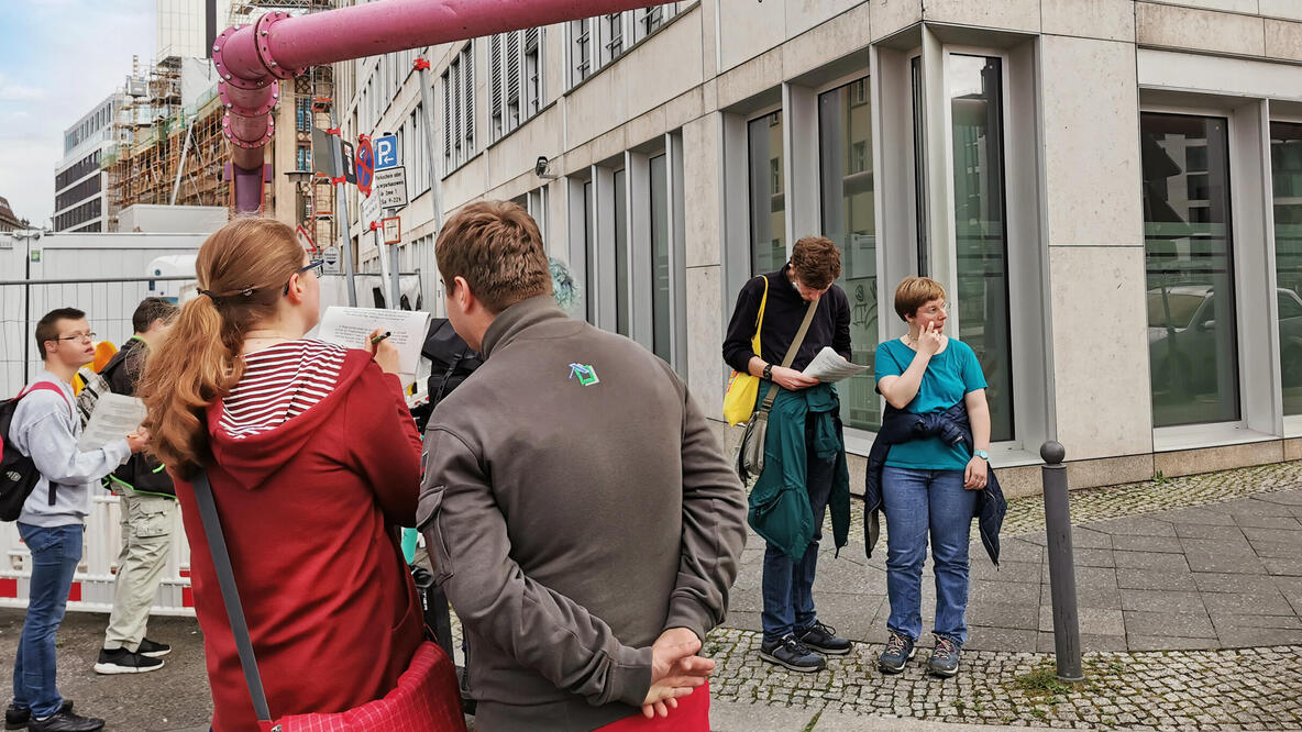 Mehrere Personen beim Rätseln auf einer Stadtrallye.