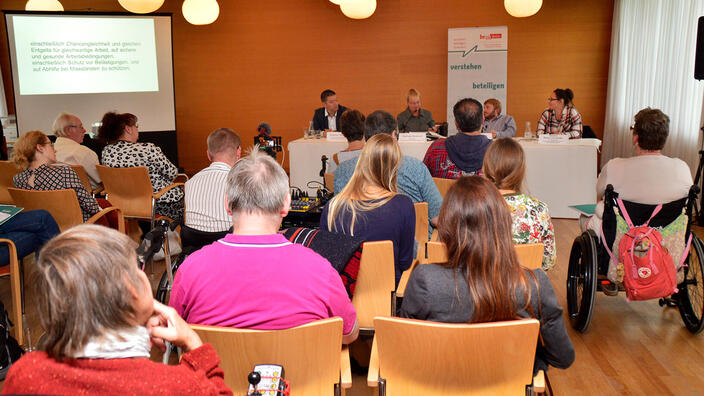 Blick über das Publikum auf das Podium bei der Veranstaltung Menschen.Rechte: Arbeit.