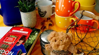 Foto: Ein Tisch voller Krimskrams - Kaffebecher, ein Buch, ein Stofftier, eine Ausstechform