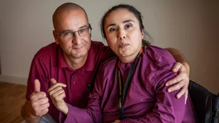 Foto von einem Mann und einer Frau, die im Rollstuhl sitzt.