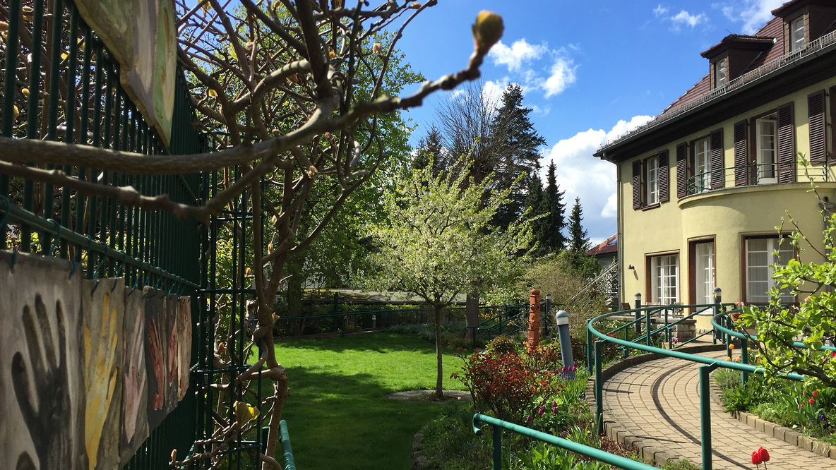 Foto: Der vordere garten der Villa Donnersmarck an einem Sommertag, blauer Himmel, das Haus ist rechts zu sehen