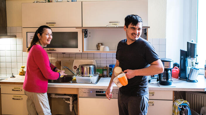 Eine Frau und ein Mann erledigen den Abwasch in der Küche.