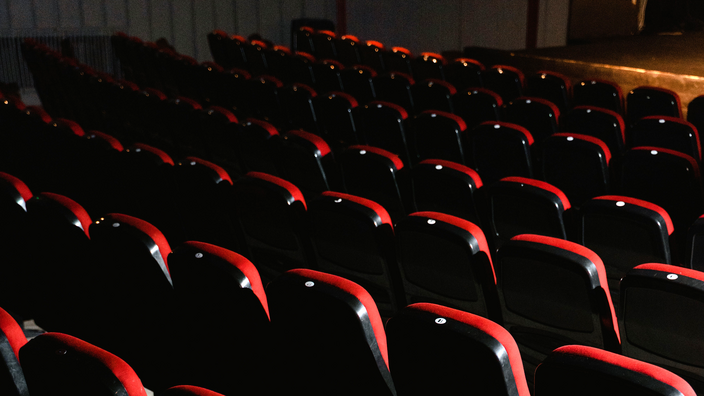 Foto: Sitzreihen in einem Opernhaus, im Hintergrund im Anschnitt die Bühne