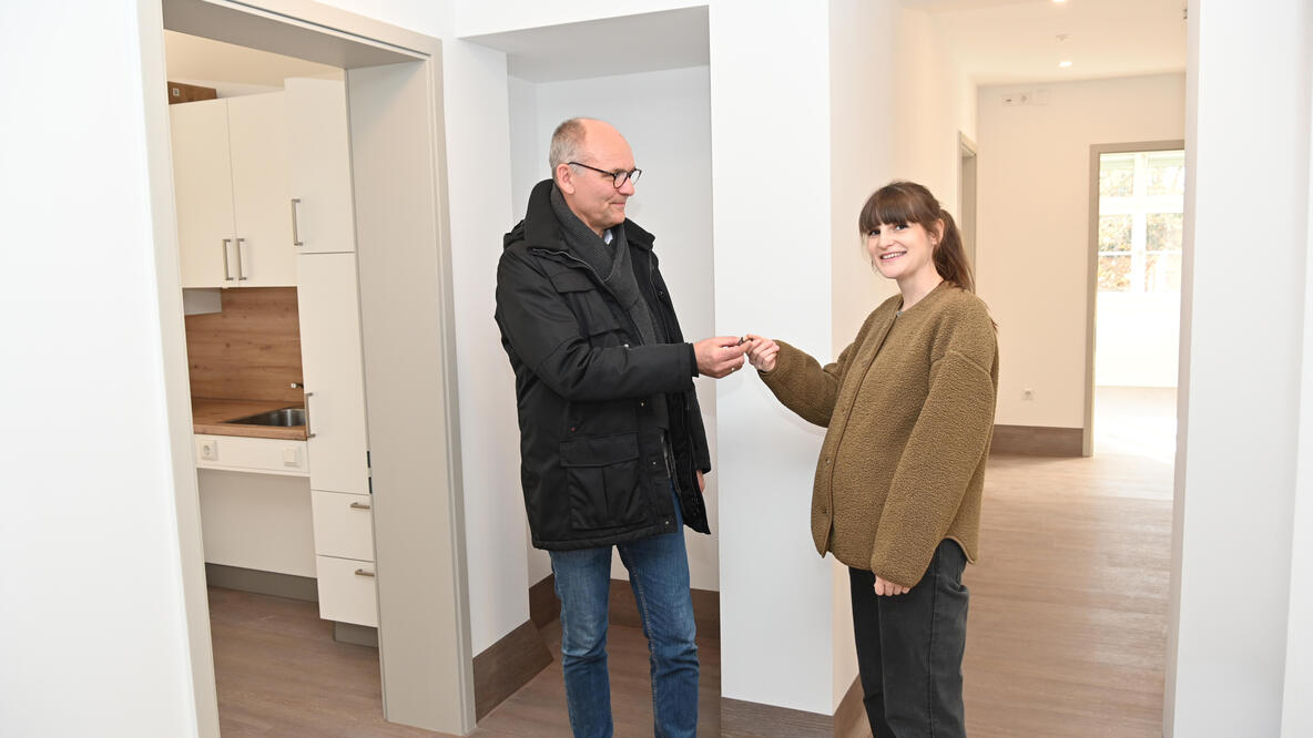 Ein Mann übergibt einer Frau einen Schlüssel.