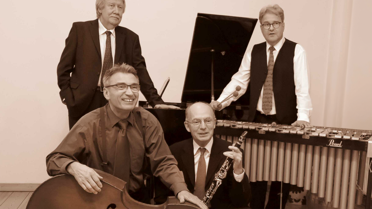 Foto: Die Dreamland Swing Band, vier reifere Herren mit ihren Instrumenten in Schwarz-Weiß.