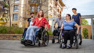Mehrere Personen, davon zwei im Rollstuhl, vor dem WMI Pankow.